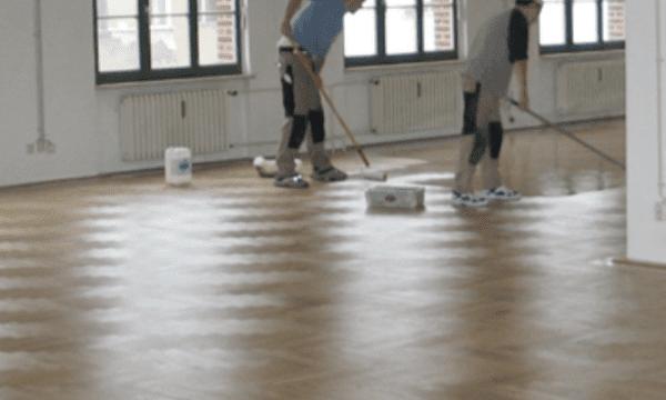 Mitarbeiter bei der Reinigung und Pflege Parkettboden